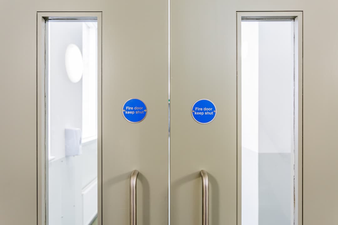 pair of fire doors with windows and fire door signs on